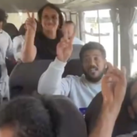 Activists from the intercepted Gaza-bound Global Sumud Flotilla flash victory signs as they are deported from Israel to Jordan via the Allenby Bridge crossing, in a video published October 7, 2025. (Screen capture: X/International Committee to Break the Siege of Gaza)